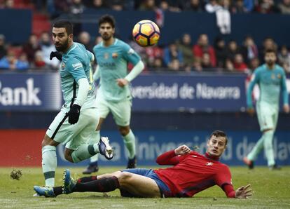 El delantero de Osasuna Oriol Riera intenta robar el esférico ante el centrocampista turco del F.C Barcelona Arda Turan.