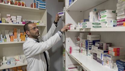 Un farmacéutico busca un medicamento en su oficina de Sevilla.
