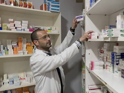 Un farmacéutico busca un medicamento en su oficina de Sevilla.