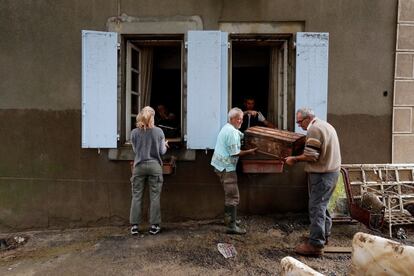 Un grupo de vecinos limpian sus viviendas tras las inundaciones en Villegailhenc (Francia).