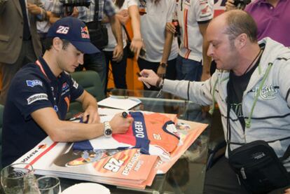 El piloto Dani Pedrosa firma en Aragón una camiseta a un admirador