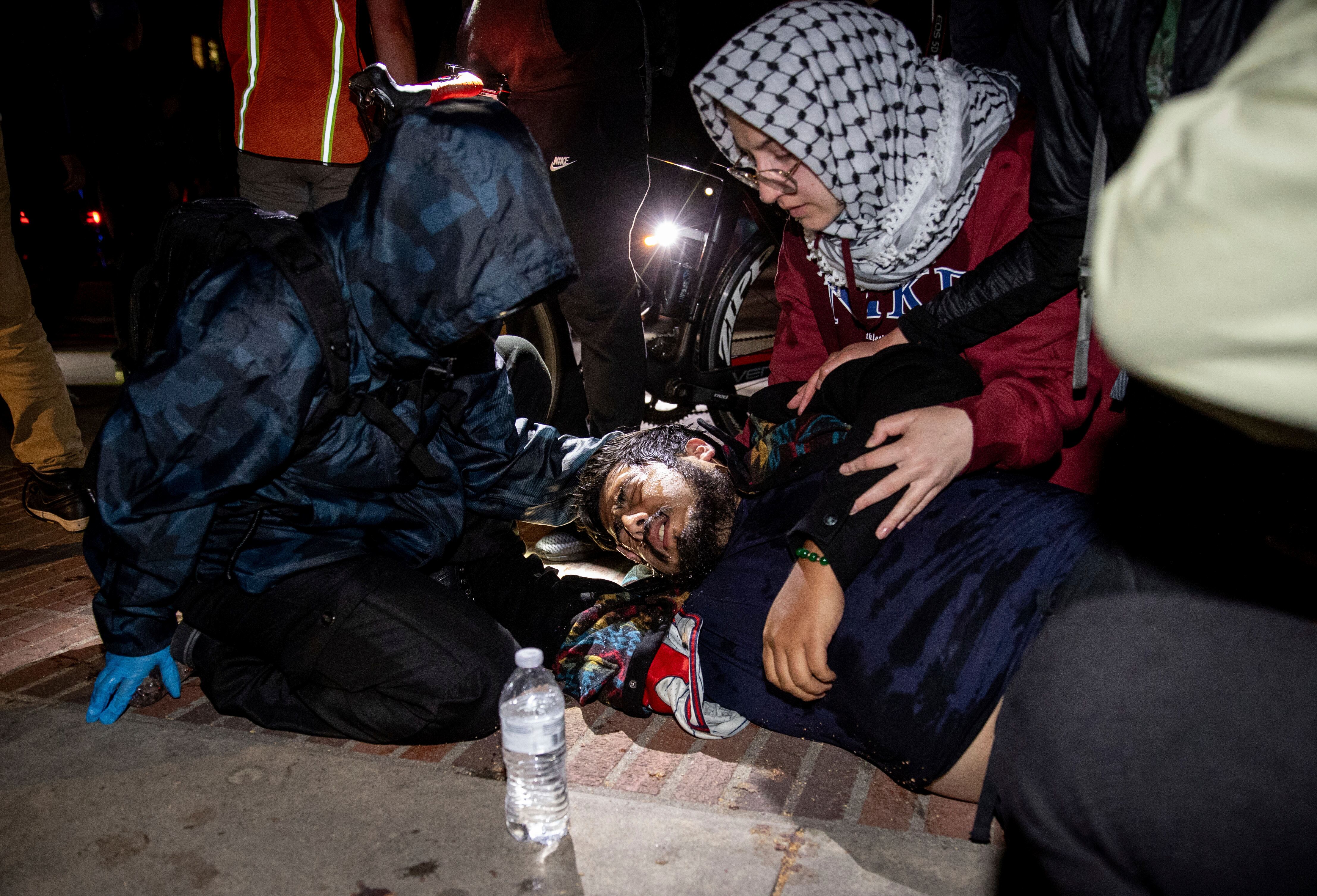 Un hombre lastimado es atendido al interior del campamento pro-Palestina, el martes cerca de la medianoche.