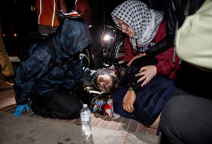 Un hombre lastimado es atendido al interior del campamento pro-Palestina, el martes cerca de la medianoche.