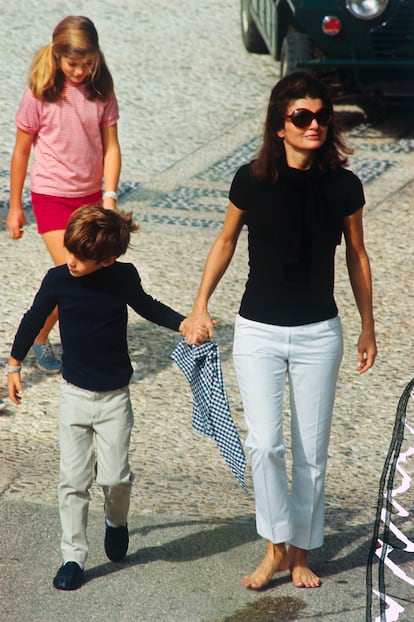 Los pajes. Junto a Jackie estuvieron sus hijos, nacidos de su matrimonio con JFK: John Jr., y Caroline, entonces de 7 y 10 años, llevaron las velas blancas de la tradición ortodoxa. Los hijos de Onassis de su primer matrimonio, Alexander, de 20 años, y Christina, de 18, observaron desde un rincón de la pequeña capilla. Los cuatro vieron a Jackie Kennedy y Aristóteles Onassis intercambiar anillos de oro en una ceremonia oficiada por el padre Polykarpos Athanassiou, un sacerdote griego ortodoxo de 31 años y amigo cercano de Onassis. 