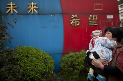 Una mujer lleva en brazos a su hijo después del ataque ocurrido en la escuela de Taixing.