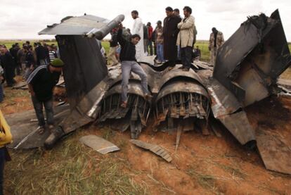 Un grupo de libios inspecciona los restos del F-15 que cayó por accidente en el pueblo de Bu Mariem.