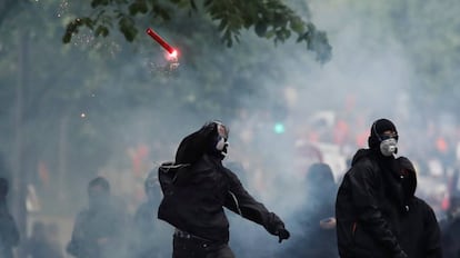 Unos encapuchados lanzan una bengala, este martes en París.