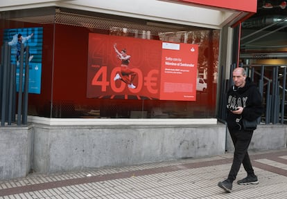 Una persona frente a una sucursal bancaria, en Madrid.