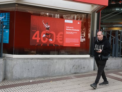 Una persona frente a una sucursal bancaria, en Madrid.