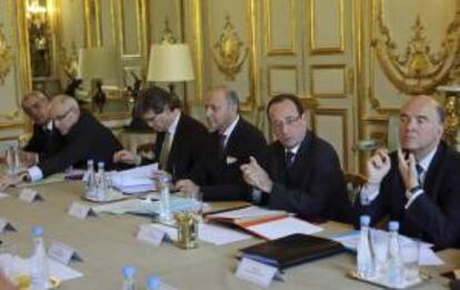El ministro de Asuntos Exteriores, Laurent Fabius (izda), el presidente François Hollande (centro), y el ministro de Economía y Finanzas Pierre Moscovici (dcha) asisten a una reunión de inversiones estratégicas del gobierno en el Palacio del Elíseo en París (Francia) hoy, miércoles 24 de abril de 2013.