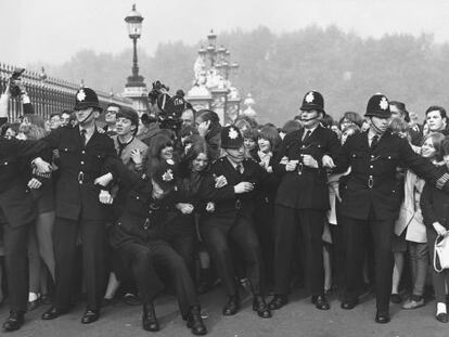 La polic&iacute;a trata de contener a los fans de The Beatles a las puertas de Buckingham Palace, donde fueron condecorados con la medalla del Imperio brit&aacute;nico en octubre de 1965.