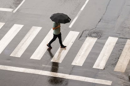 Un hombre se protege de la lluvia a primera hora del pasado miércoles en Teruel.