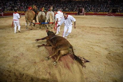 Los caballos arrastran al toro -ya fallecido- por la arena del ruedo, durante la novillada de sanfermines, el 5 de julio de 2018.