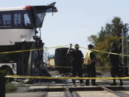 Varios policías trabajan en el lugar donde se produjo una colisión entre un autobús de dos pisos y un tren de pasajeros de la compañía Via Rail que se dirigía hacia Toronto, en un paso a nivel situado en las cercanías de Ottawa (Canadá), este miércoles 18 de septiembre de 2013.