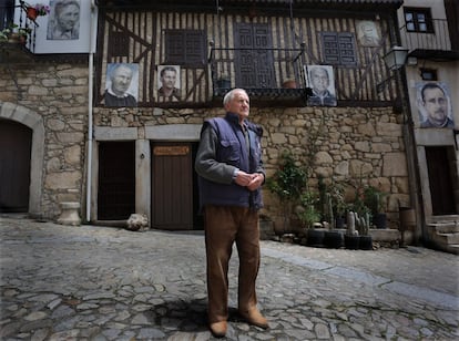 Sebastián posa frente a su casa. Al fondo puede verse su retrato, 51 años más joven, junto al de sus familiares. Actualmente, continúa trabajando la madera para hacer, entre otras muchas cosas, bastones y herramientas.