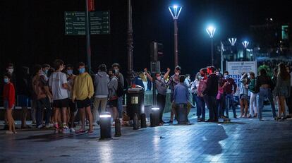 Un grupo de jóvenes se concentra en el puerto de San Sebastián durante la madrugada de este domingo. 