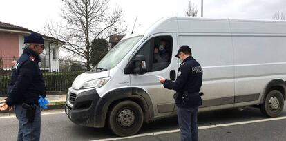  Dos operarios de la Policía Local italiana hacen guardia este martes en uno de los puestos de control para entrar en un municipio en cuarentena en la 