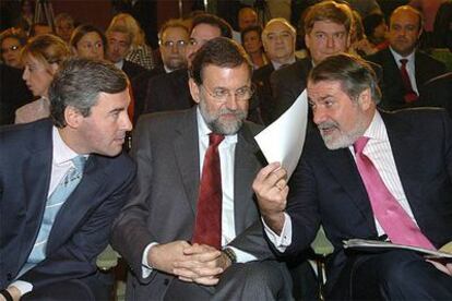 Mariano Rajoy, entre Ángel Acebes, a la izquierda, y Jaime Mayor Oreja, en un acto celebrado ayer en Madrid.