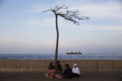 Un grupo de gente en el malecón del puerto de Muara Baru en Yakarta, Indonesia.