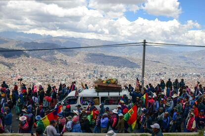 Un grupo de personas asisten a una procesión fúnebre de ocho partidarios del expresidente boliviano Evo Morales, asesinados cuando las fuerzas de seguridad levantaron un asedio a una planta de combustible, desde El Alto a La Paz.