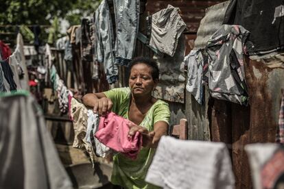 Beatriz tiende la ropa limpia en el albergue temporal de Canta La Rana, donde vive desde que el huracán Georges destrozara su vivienda en 1998.