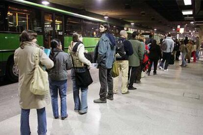 Usuarios del transporte público esperan la llegada de autobuses ayer en el intercambiador de Príncipe Pío.
