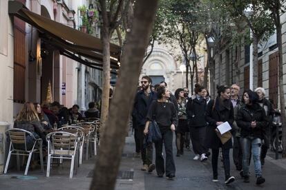 Un grupo de personas pasea por delante de las terrazas de la calle Torrijos, en el barrio de la Vila de Gràcia