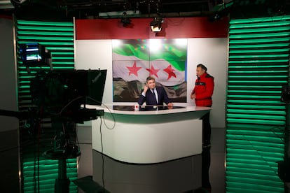 Plató de la televisión estatal siria, con la bandera de la oposición siria. 