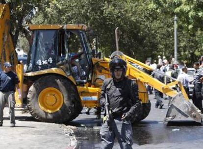 Un policía israelí hace guardia ante la excavadora con la que se llevó a cabo el ataque de ayer en Jerusalén.