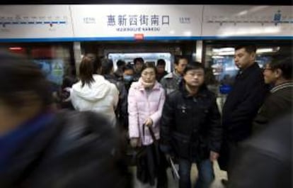 Pasajeros salen del metro en la hora punta, en Pekín (China). EFE/Archivo