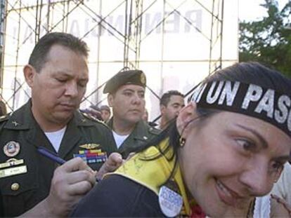 El coronel Aguedo Rogelio d'Hoy firma un autógrafo a una oponente al presidente venezolano Chávez.