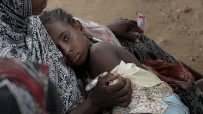 A mother hugs her daughter while receiving medical assistance in Um Sangour, Sudan. 