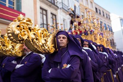 Hombres de trono (que cargan las imágenes religiosas sosteniendo varales con el hombro) portan a Nuestro Padre Jesús Nazareno de los Pasos en el Monte Calvario durante el recorrido procesional en Málaga, el 16 de abril de 2019.