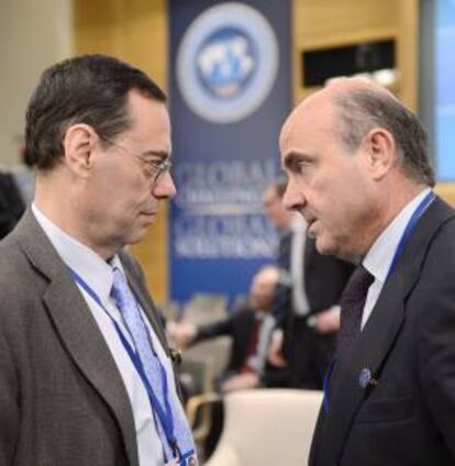 El ministro de Economía español, Luis de Guindos (d) habla con Jaime Caruana (i), director del Banco Internacional de Pagos, durante la asamblea conjunta del Fondo Monetario Internacional (FMI) y el Banco Mundial (BM) celebrada en Washington.