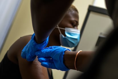 Un sanitario vacuna contra la covid a un ciudadano en una hospital a las afueras de Johannesburgo.