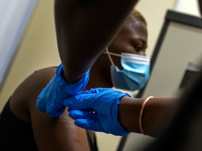 Un sanitario vacuna contra la covid a un ciudadano en una hospital a las afueras de Johannesburgo.