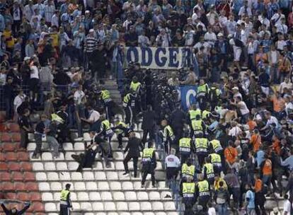 Miembros de seguridad de la UEFA y agentes antidisturbios cargan contra hinchas del Marsella.