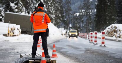 Un policía vigila una carretera en dirección a Davos.