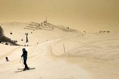 Varios esquiadores, en la estación alpina de Anzere (Suiza), con el cielo encapotado por el polvo en suspensión del Sáhara.