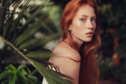 Young woman resting among ferns