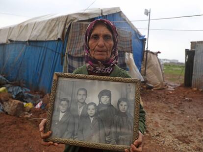 Una desplazada siria muestra una foto familiar en una aldea de Idlib.