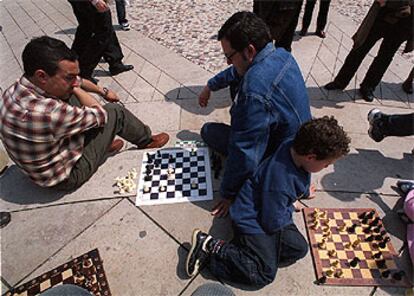 Varios ajedrecistas de todas las edades juegan en tableros improvisados durante la concentración de ayer en la plaza Moyúa.