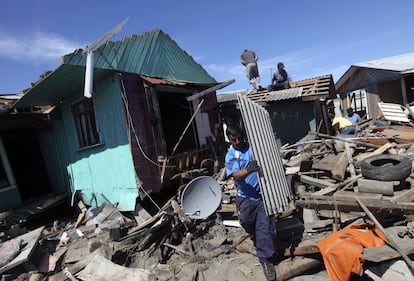 Un hombre saca escombros de su casa en Tubu.