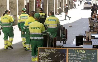 Un grupo de trabajadores de limpieza, escoltados por la Polic&iacute;a Municipal, cerca de la Plaza Mayor. 