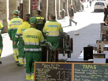 Un grupo de trabajadores de limpieza, escoltados por la Polic&iacute;a Municipal, cerca de la Plaza Mayor. 