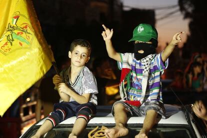Dos pequeños, uno sosteniendo una bandera islámica, contemplan las celebraciones de los palestinos. El acuerdo entre Hamás e Israel llega tras unas siete semanas de conflicto.