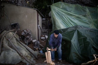 Samir Suleiman cuts firewood near his house in Mayfouq.