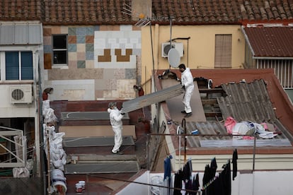 Dos operarios retiran una tejado de amianto (fibrocemento) en una vivienda en el barrio de Navas, Barcelona, el 2 de diciembre de 2022.