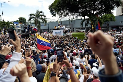 Ciudadanos alzan el puño al pasar Edmundo González y María Corina Machado, en la marcha multitudinaria de la oposición.