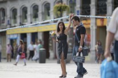 Una pareja de turistas sortea esta mañana el cordón policial en la Puerta de Sol.